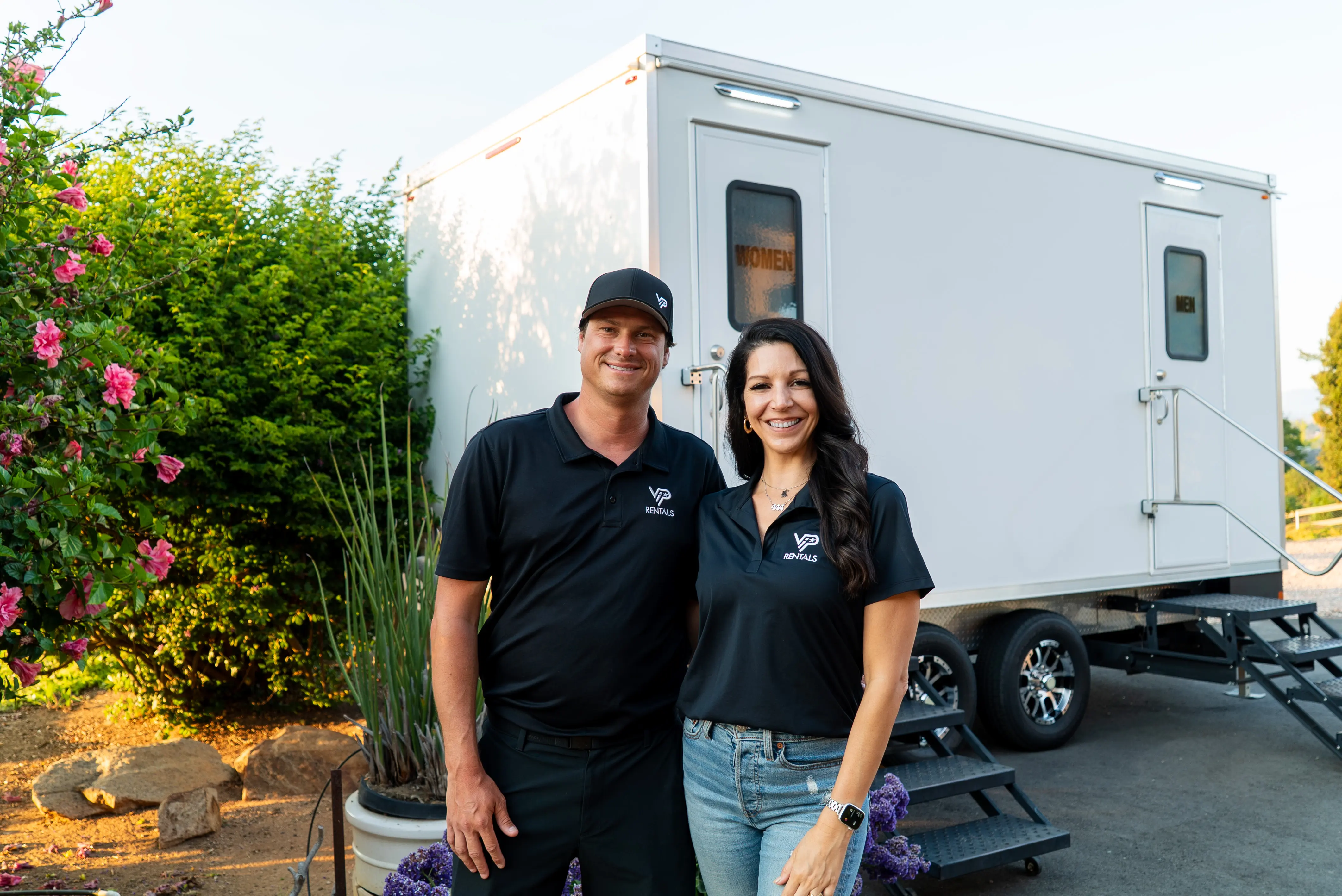 VIP Rentals, LLC owners Grant and Kinsey Hebner in front of a luxury restroom trailer rental.