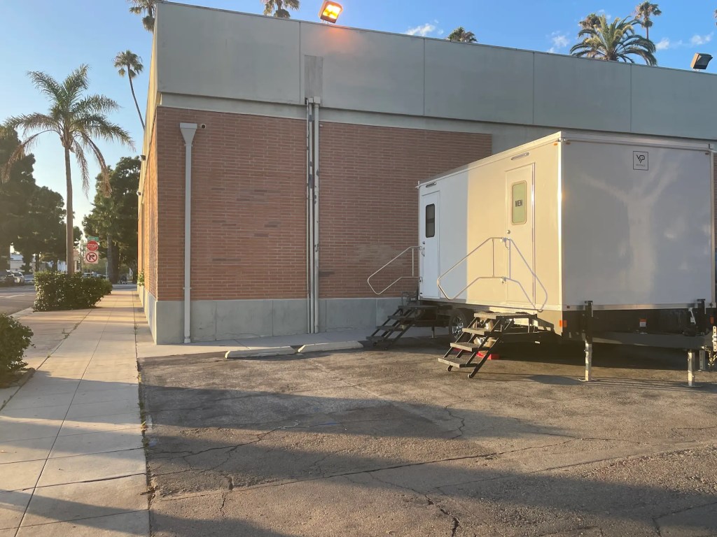 Luxury restroom trailer outside of n Oceanside, California building during a bathroom renovation.