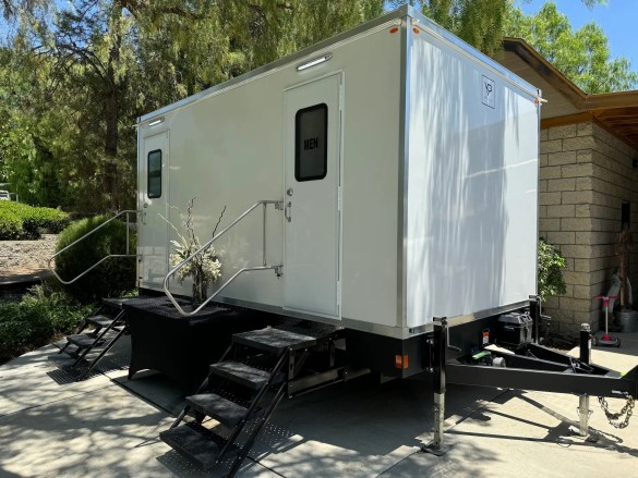 VIP Rentals, LLC 5-station luxury restroom trailer decorated with flowers at a Temecula, CA wedding.
