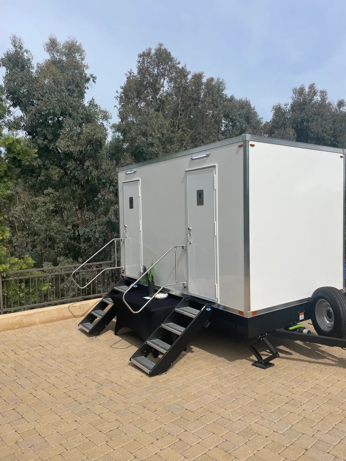 50th Birthday Party Rancho Santa Fe Side view of the luxury bathroom trailer at a Rancho Santa Fe, CA birthday party with trees in the background.