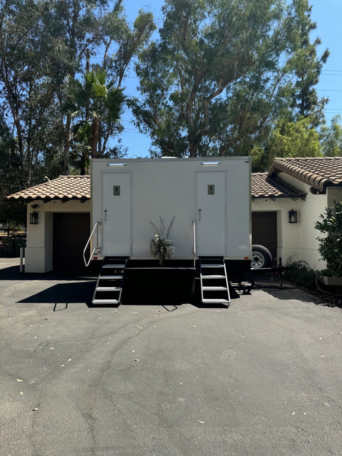 Backyard Wedding Poway Luxury bathroom trailer parked in front of a building at a Poway, California wedding.