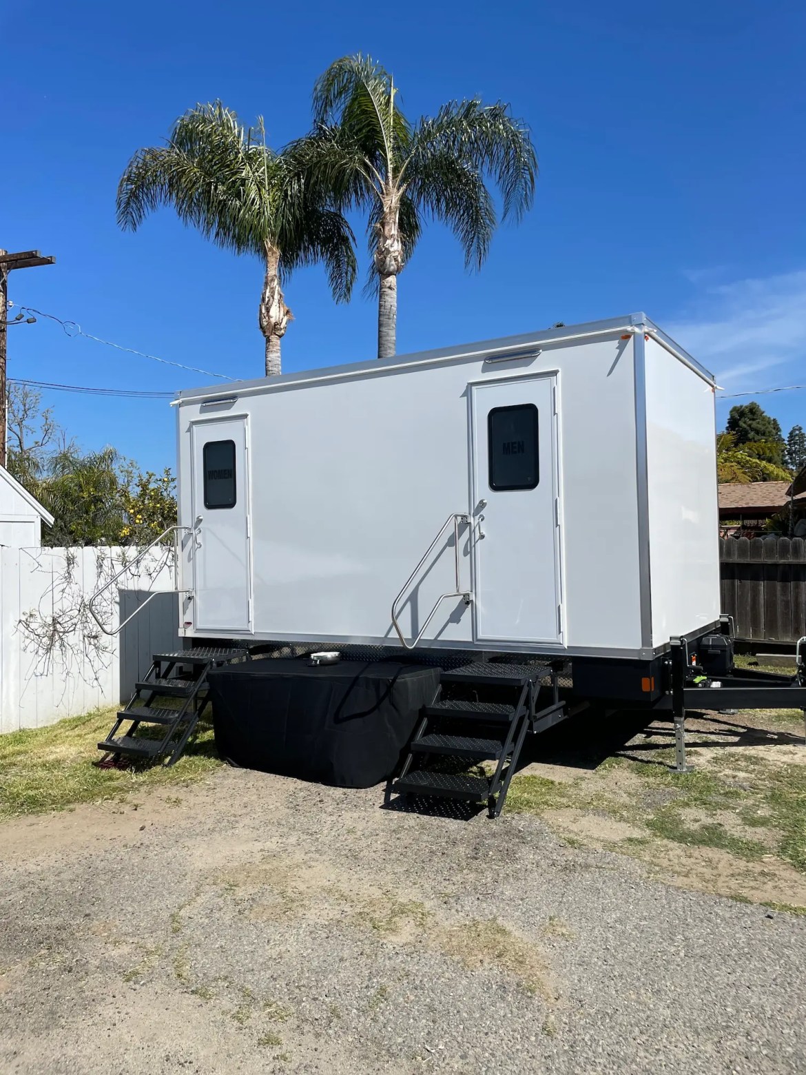 Wedding Oceanside VIP Rentals, LLC luxury restroom trailer parked in front of palm trees at a wedding in Oceanside, California.